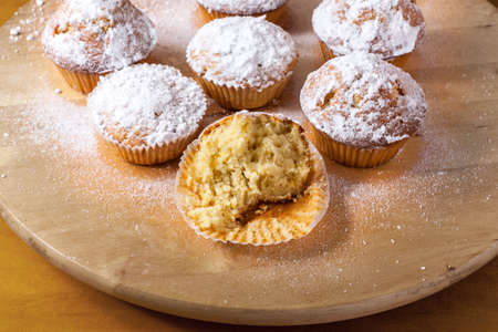Homemade cupcakes on a wooden cutting board.の写真素材