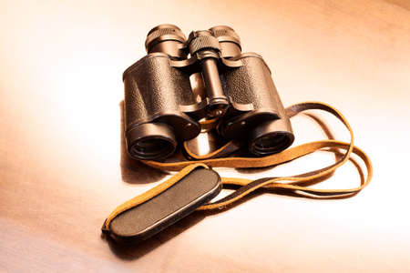 Vintage binoculars on old wooden table.の写真素材