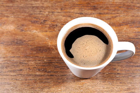 Coffee mug on an old wooden table - copy space.の写真素材