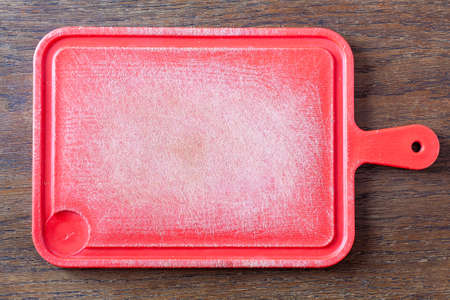 Vintage plastic cutting board on an old rustic wooden table.の写真素材