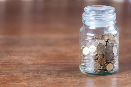 Jar savings spare change concept dark wood background.の写真素材