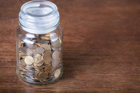 Jar savings spare change concept dark wood background.の写真素材