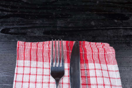 Retro old vintage cutlery knife fork natural wooden background kitchen red clothの写真素材