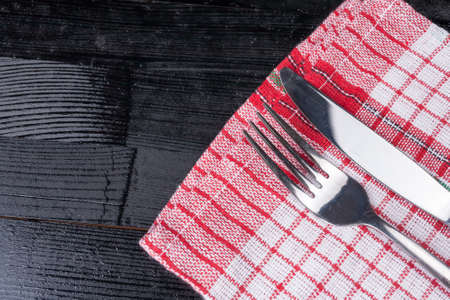 Retro old vintage cutlery knife fork natural wooden background kitchen red clothの写真素材