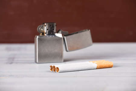 Vintage retro scratched lighter natural wooden grey brown light background cigarettesの写真素材