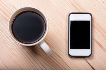 Black coffee laptop notebook business generic phone natural wooden light background top viewの写真素材