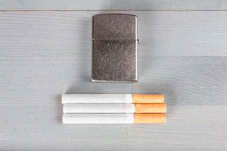 Vintage retro scratched lighter natural wooden grey brown light background cigarettesの写真素材