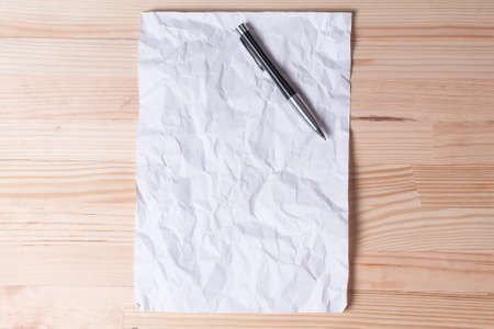 Crumpled old paper letter pen natural light wooden backgroundの写真素材