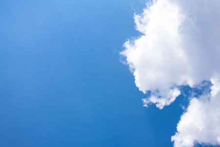 Blue sky background with white fluffy cloudsの写真素材