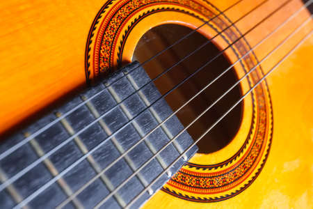 Strings, rose and neck of a yellow and orange guitar. Musical instrument.の写真素材