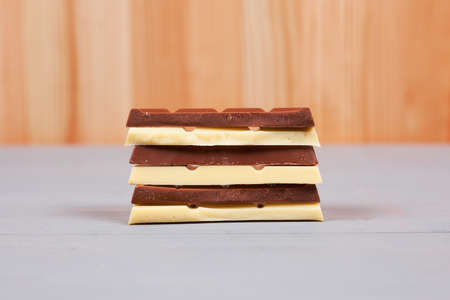 White and milk chocolate bars on natural and grey wood background.の写真素材