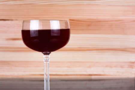Glass of wine on natural wooden background. Copy space to the right.の写真素材
