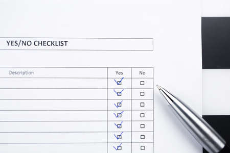 Checklist with a pen. Yes or no choice with elegantballpen on striped background.の写真素材