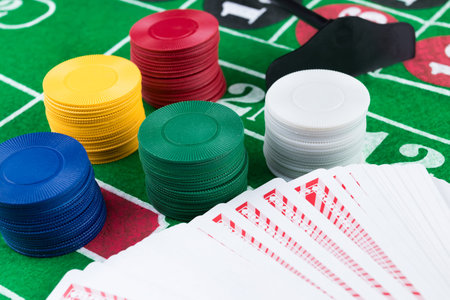 Casino chips and pile of cards on green table. Gambling problems abstract concept.