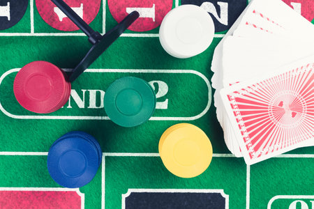 Casino chips and pile of cards on green table. Gambling problems abstract concept. Vintage colors.
