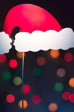 Christmas Santa Claus hat photo booth props. Tree lights colorful bokeh background.の写真素材