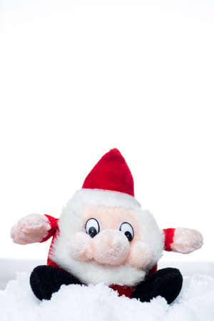 Funny christmas santa claus red and black mascot. Sitting on a snow. White isolated background. Vertical orientation. Copy space at the top.の写真素材