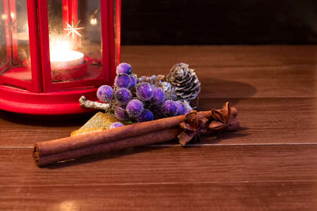 Christmas ornaments with red lantern on brown natural wooden table. Black background.の写真素材