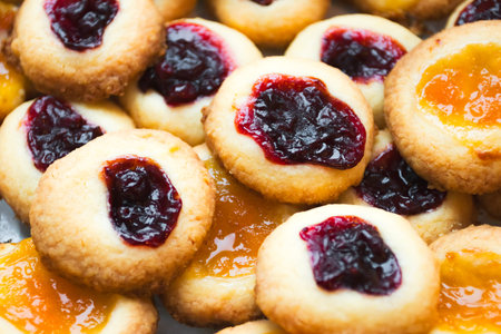 Homemade cookies filled with red and orange jelly jam on a baking paper. Domestic kitchen.の写真素材