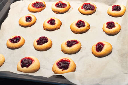 Cookies filled with jelly jam on baking paper. Domestic kitchen cooking.の写真素材