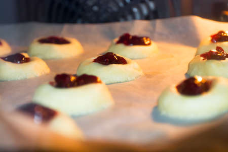 Unbaked cookies filled with jelly jam in the oven. Domestic kitchen baking.の写真素材