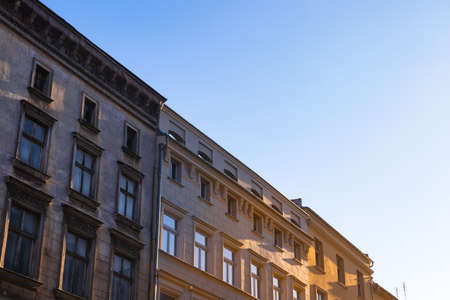 Old residential tenement houses during sunset. Bright warm afternoon light. Blue sky.の写真素材