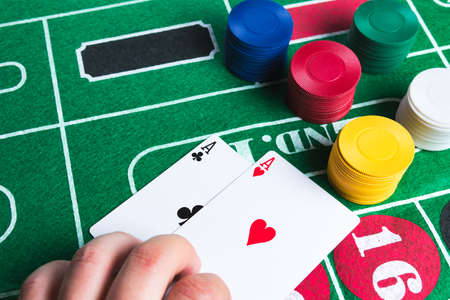 Two aces with chips on green casino table. Gambling and winning abstract concept. Copy space in the top left corner.の写真素材