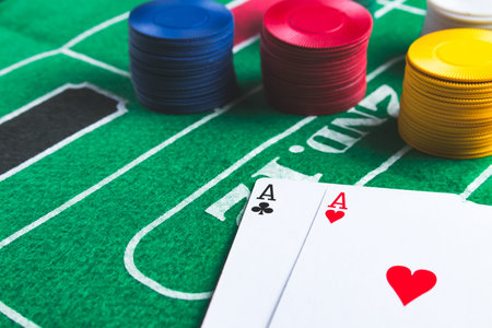 Two aces with chips on green casino table. Gambling and winning abstract concept. Angle view. Copy...