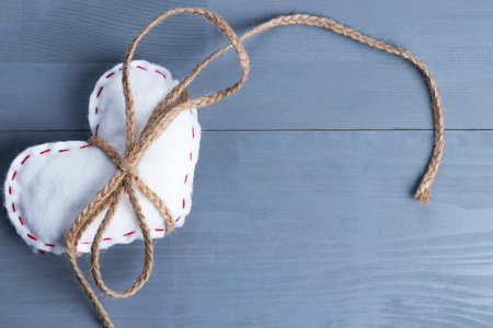 White homemade heart as a present or gift with twine on Valentine's Day. Copy space on the right.の写真素材
