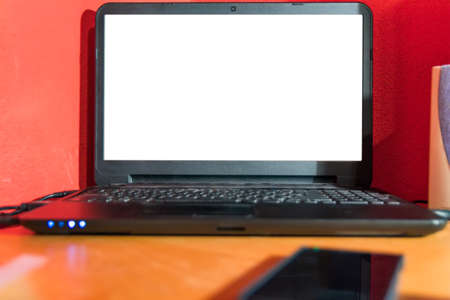 Laptop computer with white screen ready for mockup on a desk at home.の写真素材