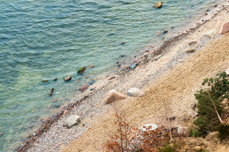 Turquoise sea and sand on a shore with rocks. Coastline as a background.の写真素材