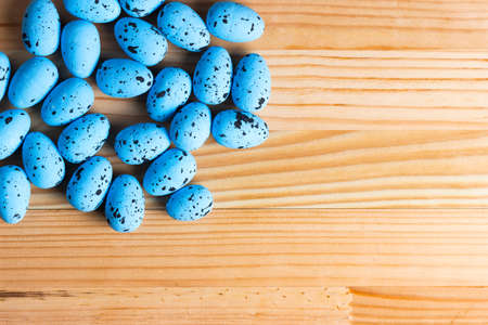 Blue bird eggs on natural wooden background. Flat lay top view. Copy space on the right.の写真素材