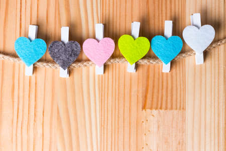 Colorful hearts on twine on natural wooden background. Copy space on the bottom.の写真素材