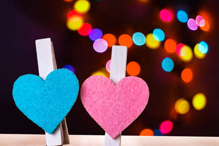 Blue and pink hearts on a clips against colorful bokeh background. Love and togetherness abstract concept.の写真素材