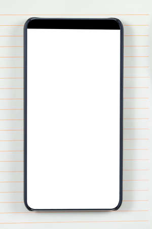 Bezel less smartphone with blank screen on a notepad background. Ready for mobile application mockup.の写真素材