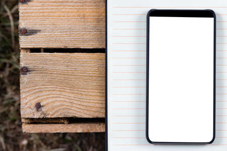 Notepad and bezel less smartphone with blank screen. Ready for mobile application mockup.の写真素材