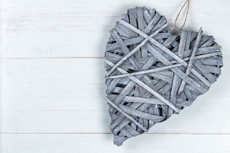 Wooden Valentines Day heart on a string on white background. Copy space on the left.の写真素材