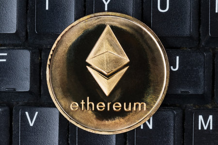 Gold physical Ethereum coin on computer keyboard. Cryptocurrency shopping abstract concept.