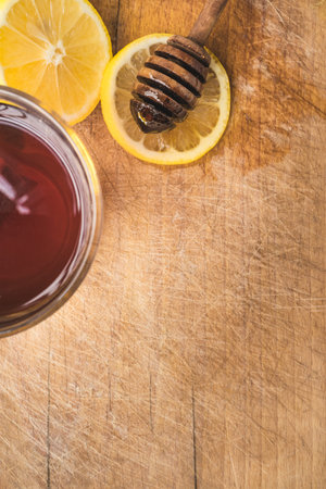 Natural cold treatment and remedies on wooden background. Hot tea with organic lemon and honey.