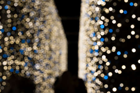 Defocused christmas or new years eve blue and golden lights background. Festive decoration.の写真素材