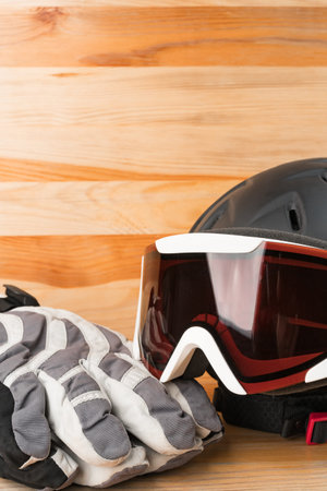 Snowboard or ski winter sports protective gear - helmet, warm gloves and goggles. Vertical orientation. Copy space on the top.