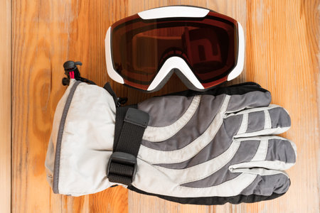 Snowboard or ski winter sports protective gear - warm gloves and goggles. Flat lay top view.
