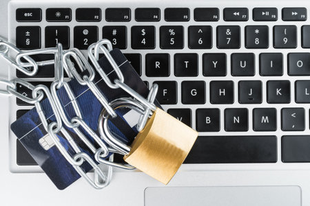 Padlock with chain and credit card on a laptop computer keyboard. Online shopping security abstract...