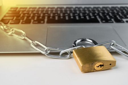 Padlock and chain with laptop computer on a white background. Cyber security abstract concept.の写真素材