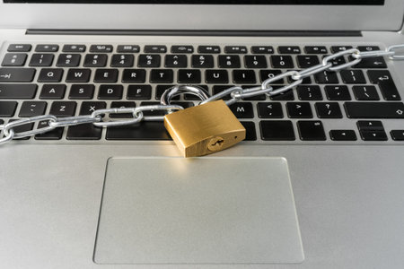 Padlock with chain on a laptop computer keyboard. Cyber security abstract concept.
