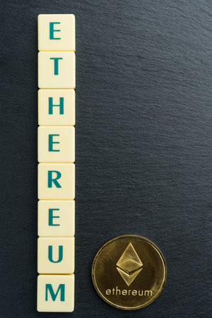 Physical Ethereum gold coin with text made out of letter tiles. Cryptocurrency. Vertical orientation. Copy space on the right.の写真素材