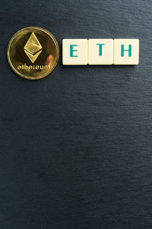 Physical Ethereum gold coin with text made out of letter tiles. Cryptocurrency. Copy space in the bottom. Vertical orientation.の写真素材