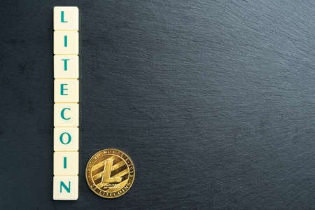 Physical Litecoin gold coin with text made out of letter tiles. Cryptocurrency. Large copy space on the right.の写真素材