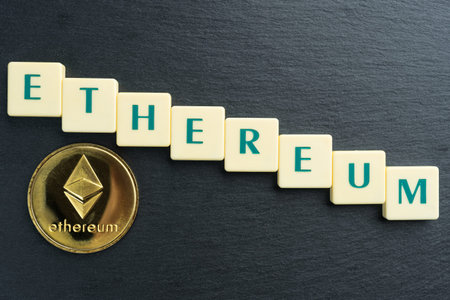 Physical Ethereum gold coin with text made out of letter tiles. Cryptocurrency decline or bear...
