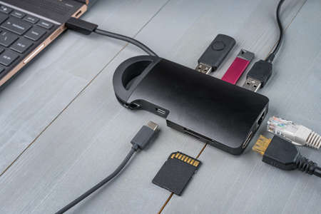 USB Type C adapter or hub connected to the laptop with various accessories - pendrives, hdmi,   memory card, cables.の写真素材